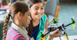 School girls examining a drone